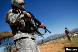 FILE - United States National Guard troops patrol along the U.S. and Mexico border in Nogales, Arizona, Oct. 8, 2010.