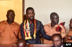 Uganda's prominent opposition politician Robert Kyagulanyi known as Bobi Wine (2L) appears at the chief magistrate court in Gulu, northern Uganda, Aug. 23, 2018.