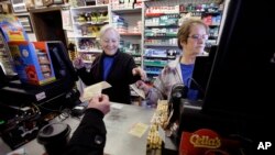 Cashiers Kathy Robinson, left, and Ethel Kroska, right, both of Merrimack, New Hampshire, sell lottery tickets Sunday, Jan. 7, 2018, at Reeds Ferry Market convenience store, in Merrimack. (AP Photo/Steven Senne)