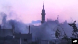 In this image made from amateur video released by the Shaam News Network and accessed June 25, 2012, smoke rises from buildings following purported shelling in Talbeesa, Homs, Syria. (AP cannot independently verify the content, date, location or authenticity of this material.)