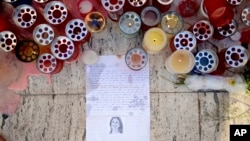Candles, notes and paper cuttings lie next to the Love Monument in St. Julian, Malta, Oct. 17, 2017, the day after the killing of journalist Daphne Galizia. 