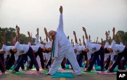 FILE - Prime Minister Narendra Modi performs yoga along with thousands of Indians on Rajpath in New Delhi, India, June 21, 2015.