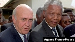 FILE - In this file photo taken on Apr. 3, 1994, ANC President Nelson Mandela (R) and South African President Frederik W. De Klerk (L) walk to an Easter church service dedicated to peace, in Moria, South Africa.