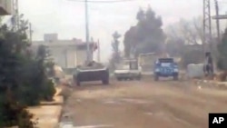 In this image from amateur video made available by the Ugarit News group purports to show military vehicles in Homs, Syria, December 21, 2011.