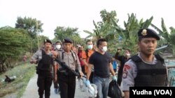 Polisi bersenjata sita barang bukti dari hasil penggeledahan di Pasar Kliwon, Solo, Rabu, 12 Agustus 2015 (Foto: VOA/Yudha)