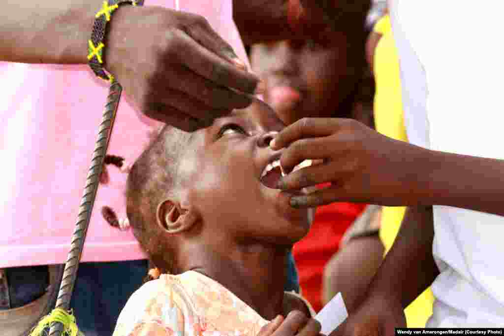 A child is given an oral cholera vaccine dose at the UNMISS Tomping camp in Juba, where tens of thousands of South Sudanese are living in makeshift shelters.