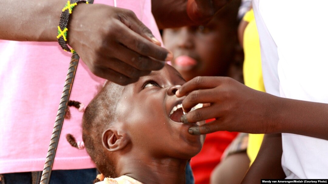 A child is given an oral cholera vaccine dose at the UNMISS Tomping camp in Juba, where tens of thousands of South Sudanese are living in makeshift shelters.