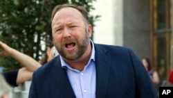 FILE- Conspiracy theorist Alex Jones speaks outside the Dirksen Senate Office Building in Washington, D.C., after listening to Facebook and Twitter executives testify before the Senate Intelligence Committee on foreign influence operations and their use of social media, Sept. 5, 2018. Twitter said Sept. 6 that it was permanently banning right-wing conspiracy theorist Jones and his "Infowars" show for abusive behavior.
