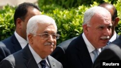 Palestinian President Mahmoud Abbas, left, and his foreign minister, Riyad al-Maliki, right, arrive for an Arab League Foreign Ministers emergency meeting at the league's headquarters in Cairo, Egypt, Sept. 7, 2014. 