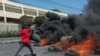 A protester burns tires during a demonstration following the resignation of its Prime Minister Ariel Henry, in Port-au-Prince, Haiti, on March 12, 2024.