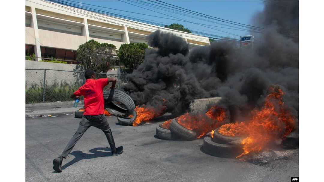 Seorang pengunjuk rasa membakar ban saat demonstrasi menyusul pengunduran diri Perdana Menteri Ariel Henry, di Port-au-Prince, Haiti, pada 12 Maret 2024. (Foto: AFP)