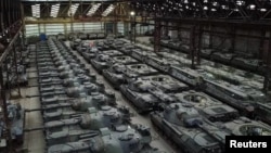 Dozens of German-made Leopard 1 tanks and other armoured vehicles are seen in an hangar in Tournais.