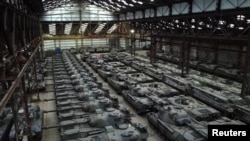 Dozens of German-made Leopard 1 tanks and other armoured vehicles are seen in an hangar in Tournais