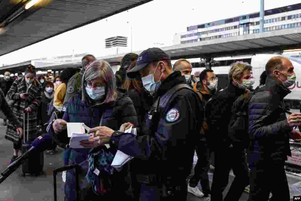 프랑스 파리의 기차역에서 경찰이 승객의 여행 승인 증명서를 검토하고 있다. 프랑스는 신종 코로나바이러스 확산을 막기 위해 여행을 제한하고 경찰 검문을 강화하고 있다. 