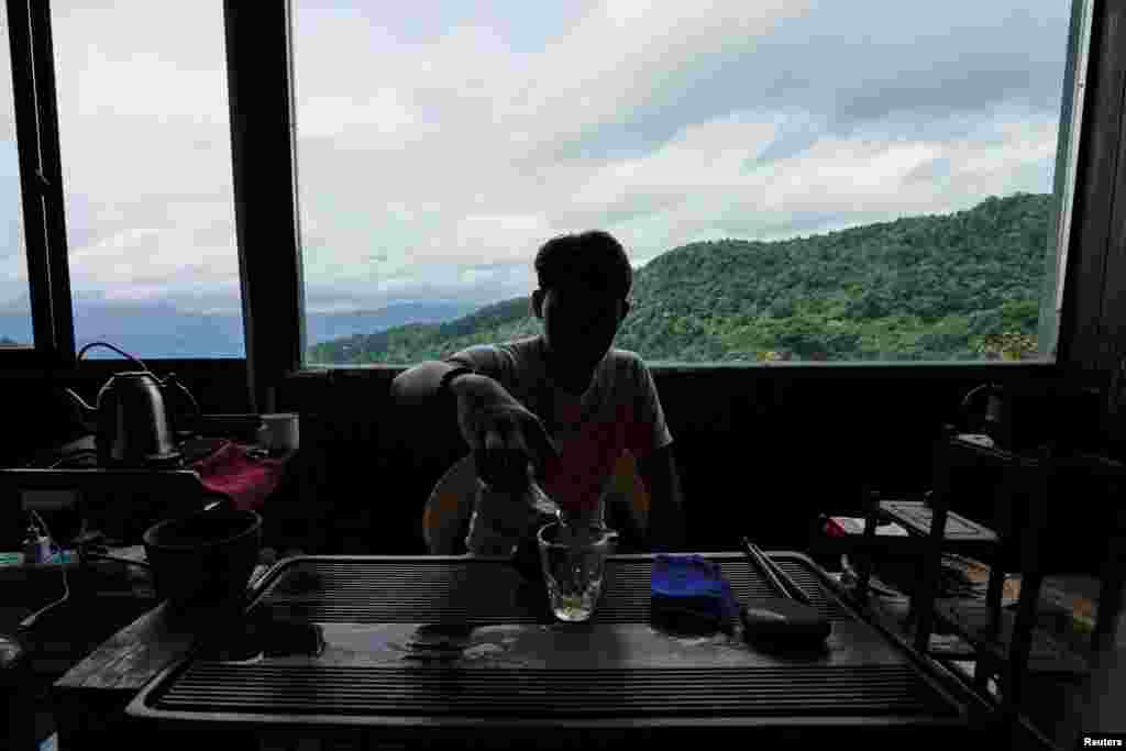 پہاڑوں کی چوٹیوں پر قائم چائے کے باغات اور ان کے درمیان بنے ایک مکان میں بیھٹا کسان چائے بنارہا ہے۔ کھڑکی سے نظر آتے باغات کا دلکش منظر قابل دید ہے۔ &nbsp;