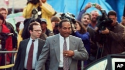 FILE - O.J. Simpson (R) and his defense attorney Daniel Leonard leave Los Angeles County Superior court in Santa Monica, Calif., Friday, Nov. 22, 1996, after testifying in the wrongful death civil trial against him. 