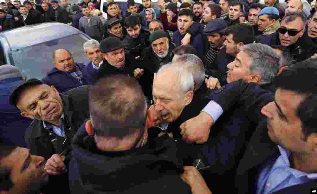 A man punches Kemal Kilicdaroglu, the leader of Turkey&#39;s main opposition Republican People&#39;s Party, during the funeral of a soldier who was slain during clashes with Kurdish rebels at Iraq border, outside Ankara, Turkey.