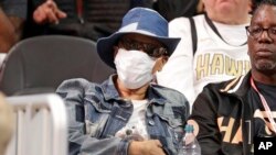 Lolita Owens, de Snellville, en Géorgie, porte un masque en attendant qu'un match de basket NBA entre les New York Knicks et les Atlanta Hawks débute le 11 mars 2020 à Atlanta. Ownes a déclaré qu'elle portait le masque en raison d'un système immunitaire affaibli. 