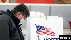 Voter Fred Hoffman fills out his ballot during the primary election in Ottawa, Illinois, U.S., March 17, 2020. The polling station was relocated from a nearby nursing home to a former supermarket due to concerns over the outbreak of coronavirus…