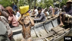 Seorang anak mandi saat keluarga dan para korban banjir yang lain antri di atas perahu untuk menerima bantuan di Prek Sussey, provinsi Kandal. Provinsi ini termasuk daerah yang paling menderita akobat bencana banjir di Kamboja.