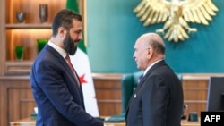 Serokê Demkî yê Sûriyê Ehmed al-Sharaa (L) Fûad Husên Wezîrê derve yê Îraqê