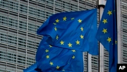 FILE—European Union flags flap in the wind outside EU headquarters in Brussels, October 16, 2019.