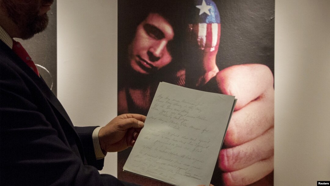 Kurator Christie's Tom Lecky memegang manuskrip asli lagu 'American Pie' oleh Don McLean di rumah lelang Christie's di New York.