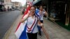 Paraguayan schoolgirls carry flags as they wear sashes a day before the inauguration of President-elect Fernando Lugo's government in Asuncion August 14, 2008.