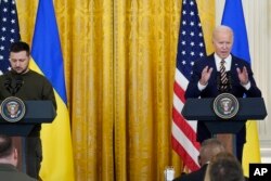 FILE - Ukrainian President Volodymyr Zelenskyy listens as President Joe Biden speaks during a news conference in the East Room of the White House in Washington, Wednesday, Dec. 21, 2022.