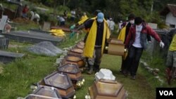 Para petugas membawa jenazah para korban tanah longsor ke tempat pemakaman di Nova Friburgo, Brazil.