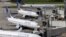 United Airlines planes are parked at their gates as another plane, top, taxis past them at George Bush Intercontinental Airport in Houston, July 8, 2015.