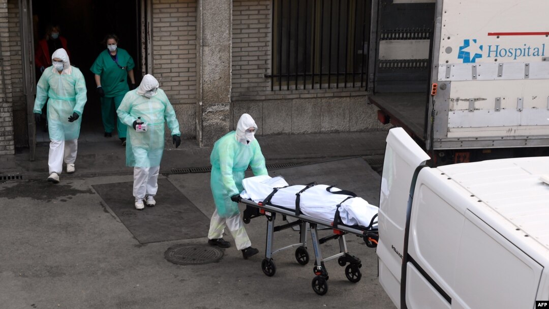 A health worker carries a body on a stretcher outside Gregorio Maranon hospital in Madrid on March 25, 2020.