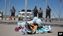 FILE- Shoes and a teddy bear, brought by a group of U.S. mayors, are piled up outside a holding facility for immigrant children in Tornillo, Texas, near the Mexican border, June 21, 2018.