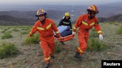 Petugas penyelamat mengevakuasi korban tewas dari lokasi lomba lari maraton di kota Baiying, provinsi Gansu, di China barat laut, Minggu (23/5). 