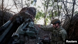 Ukrajinski vojnik priprema haubicu za pucanje na ruske trupe u oblasti Donjecka