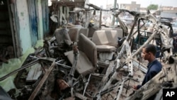 Un homme inspecte l’épave d’un bus sur le site d’une attaque aérienne meurtrière par la coalition menée par l’Arabie saoudite jeudi, à Saada, au Yémen, le dimanche 12 août 2018.