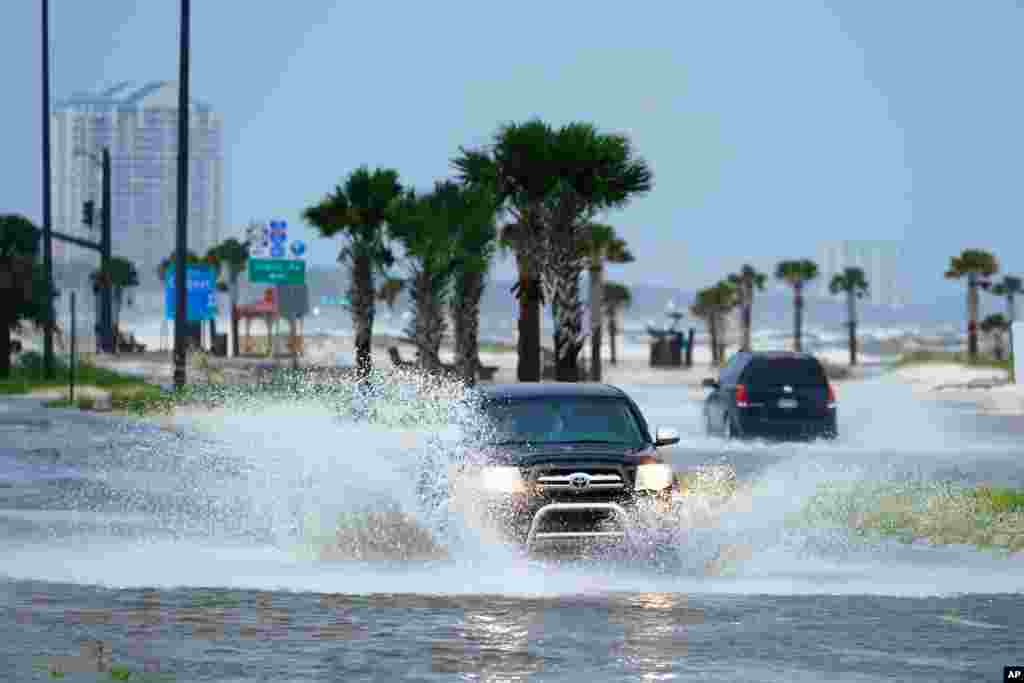 Cars drive through flood waters along route 90 as outer bands of Hurricane Ida arrive in Gulfport, Mississippi.