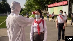 မြောက်ကိုရီးယားမှာ ကိုဗစ်ကာကွယ်တားဆီးနိုင်ရေး ကျောင်းသူကျောင်းသားတွေကို ကိုယ်ပူချိန် တိုင်းတာပေးနေတဲ့မြင်ကွင်း။ (ဇွန် ၂၂၊ ၂၀၂၁)