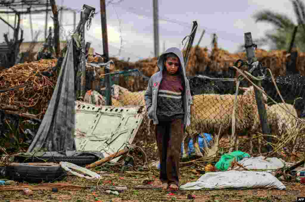 A Palestinian boy walks barefoot in the Araiba refugee camp on rainy day in Rafah in the southern Gaza Strip.