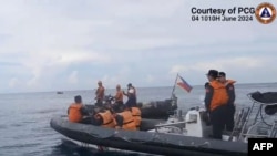 Para personel Garda Pantai China menaiki kapal karet untuk menghalangi Garda Pantai Filipina di Laut China Selatan, Jumat, 7 Juni 2024. (Foto: Garda Pantai Filipina/AFP)