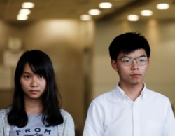 Pro-democracy activists Joshua Wong and Agnes Chow leave the Eastern Court after being released on bail in Hong Kong, Aug. 30, 2019.