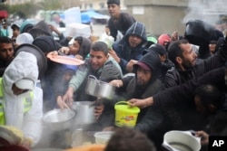 FILE - Palestinians line up for free food distribution during the ongoing Israeli air and ground offensive in Khan Younis, Gaza Strip, February 2, 2024