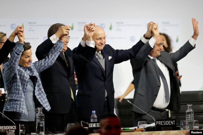 FILE - Participants react during the final plenary session at the World Climate Change Conference 2015 (COP21) at Le Bourget, near Paris, France, Dec. 12, 2015.