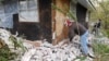 FILE - Chad Devereaux works at cleaning up the bricks that fell from three sides of his in-laws home in Sparks, Oklahoma, Nov. 6, 2011, after two earthquakes hit the area in less than 24 hours.