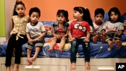 FILE - Egyptian children pose for a portrait at their home in Madinet el-Salam on the outskirts of Cairo, Egypt, May 31, 2017.