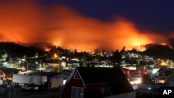 A wildfire approaches Chile's Dichato community, Jan. 30, 2017, where firefighters are working to keep the flames away from an estimated 800 homes.