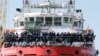 FILE - Migrants wait to disembark from "Vos Prudence" offshore tug supply ship as they arrive at the harbor in Naples, Italy, May 28, 2017.