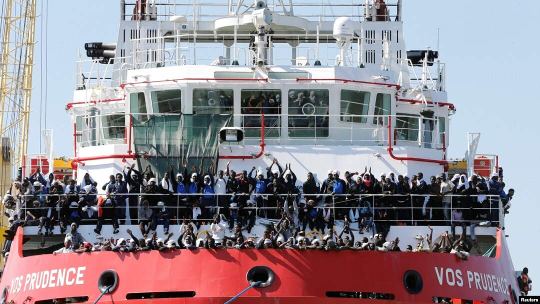 FILE - Migrants wait to disembark from "Vos Prudence" offshore tug supply ship as they arrive at the harbor in Naples, Italy, May 28, 2017.