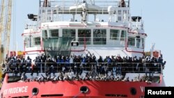 Para migran menunggu untuk turun dari kapal “Vos Prudence” saat tiba di pelabuhan di Napoli, Italia, 28 Mei 2017.
