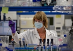 FILE - A lab technician researches COVID-19 at Johnson & Johnson subsidiary Janssen Pharmaceutical in Beerse, Belgium, June 17, 2020.